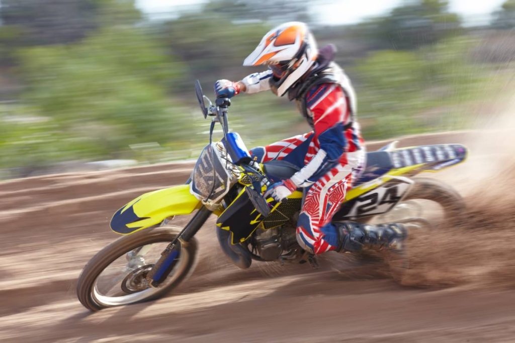 A motocross rider doing a brake slide in the dirt