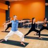 Yoga training class, female group with male trainer in action in gym. Yogi exercise indoor