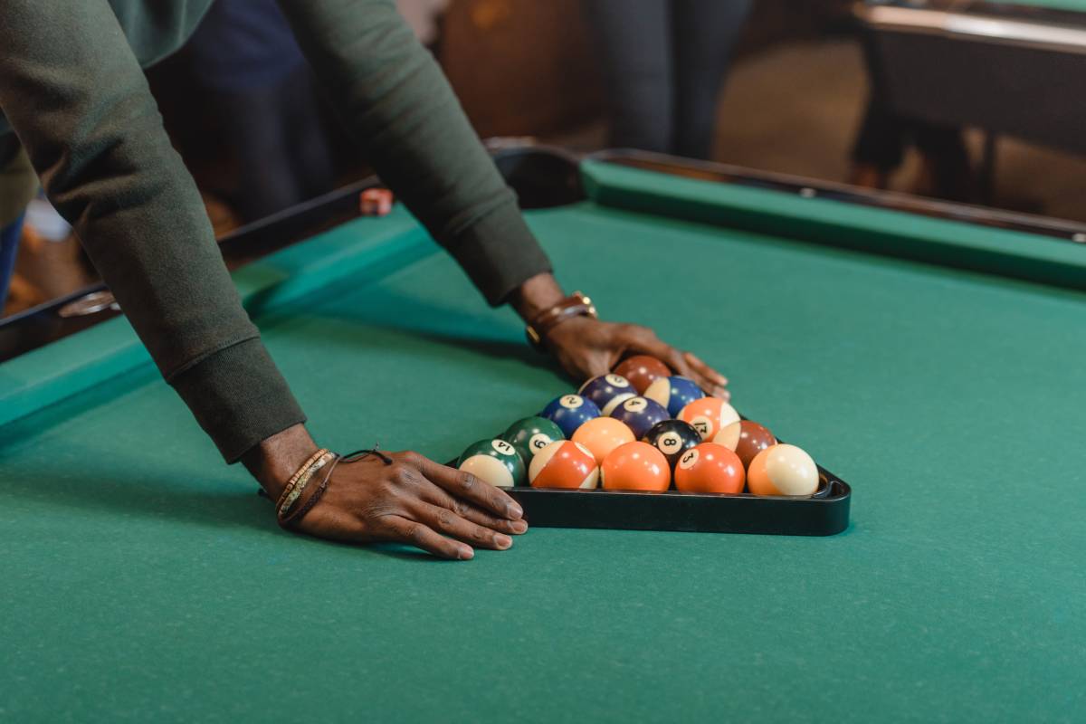 cropped image of male hands forming set of billiard balls by triangle