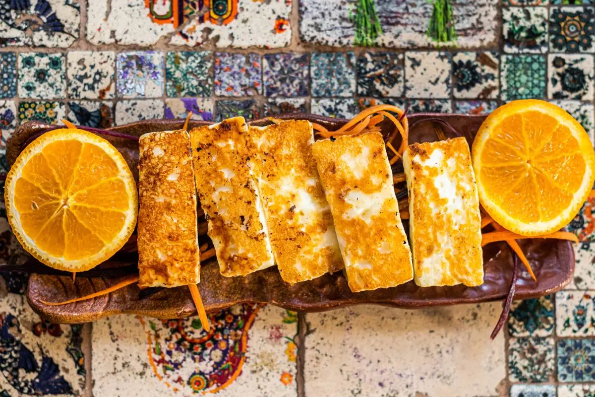 Grilled Halloumi Cheese on a plate with herbs. Top view.