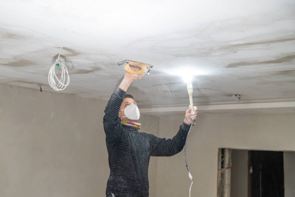 hand sanding of the plasterboard ceiling with a trowel.