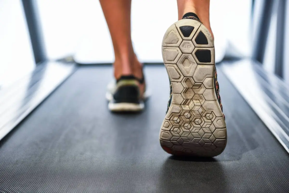Male muscular feet in sneakers running on the treadmill at the gym. Concept for fitness, exercising and healthy lifestyle.
