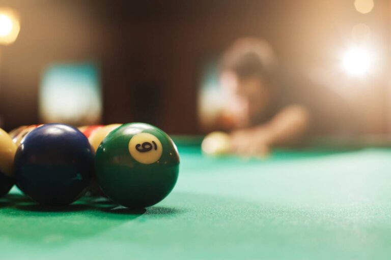 Player has prepared to hit the balls in pool. Nightlife. Pool room on the background.
